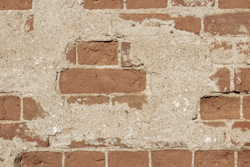Texture of old brick wall with destroyed plaster. Classic brickwork as a backdrop or background.