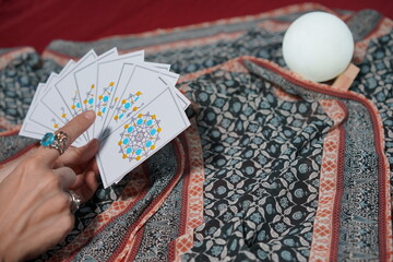 Tarot card reading on cloth for fate or fortune telling through design card. Gypsy paranormal in...