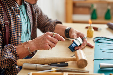 jeweler using tools and equipment for jewelry work on an antique wooden desktop, professional repaiting work of rare jewelry