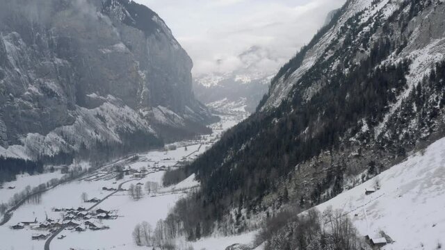 Drone Aerial of Lauterbrunnen surrounded by the Mountain Eiger in the swiss alps. The winter in Switzerland has begun and the ski and holiday season has started. Heavy snow in this resort village.