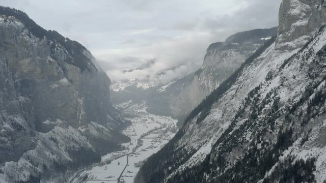 Drone Aerial of Lauterbrunnen surrounded by the Mountain Eiger in the swiss alps. The winter in Switzerland has begun and the ski and holiday season has started. Heavy snow in this resort village.