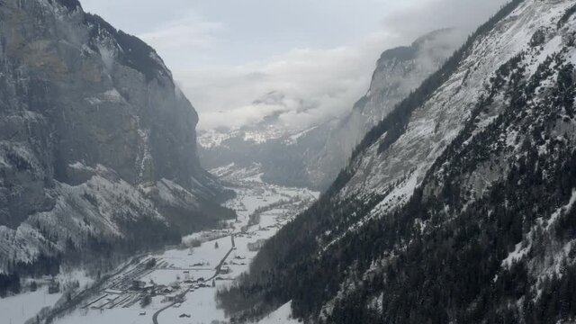 Drone Aerial of Lauterbrunnen surrounded by the Mountain Eiger in the swiss alps. The winter in Switzerland has begun and the ski and holiday season has started. Heavy snow in this resort village.