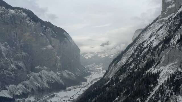 Drone Aerial of Lauterbrunnen surrounded by the Mountain Eiger in the swiss alps. The winter in Switzerland has begun and the ski and holiday season has started. Heavy snow in this resort village.