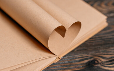 Heart made from book sheets, love and valentine concept on a wooden table