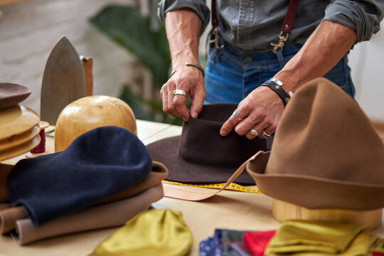 hat sewing by designer in workshop, professional craftsman making handmade hats, professional atelier giving shape to hat