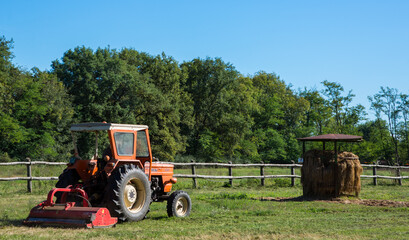 A tractor on its land under the autumn sun