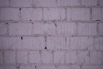 Background, texture of a pink brick wall. The bricks are arranged in rows and are painted in a delicate pink color