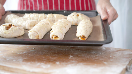 Whole wheat bread from homemade whole grain dough made by woman with red apron. Healthy pastry with many grains.