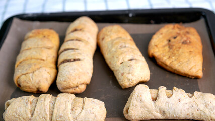 Whole wheat bread from homemade whole grain dough made by woman with red apron. Healthy pastry with many grains.