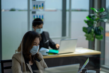 Asian business woman with colleague male in new normal social distancing office with colleague