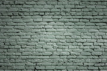 Fragment of old brickwork, wide plan. A wall of red, rose, green and grey stones. Potholes and defects in a brick wall, side view. 