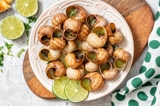 Escargots de Bourgogne. Snails with butter, herbs, and garlic in a plate top view.