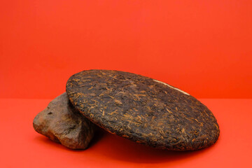 Aged quality puer tea on a red background. Grown on red mountain soils.