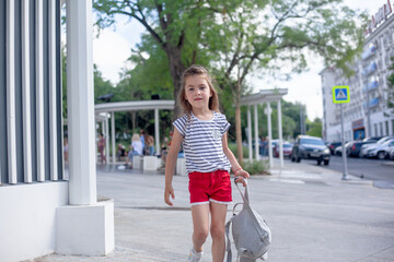 Five years old walking in the park with bagpack