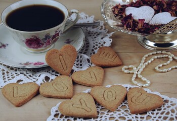 Fototapeta premium I love you - cookie note, heart shape cookies with love confession, coffee cup, Valentines image vintage style, wyznanie miłości przy kawie, sznur perełek