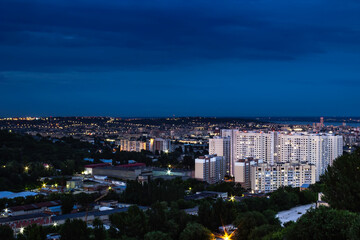 View of the city with high-rise buildings against the background of the river and sunset.