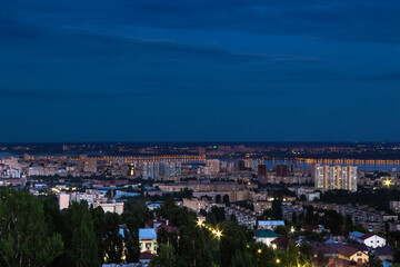 Fototapeta premium View of the city with high-rise buildings against the background of the river and sunset.