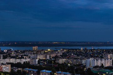 Fototapeta premium View of the city with high-rise buildings against the background of the river and sunset.