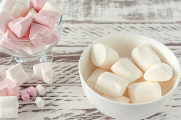 Assorted pink and white marshmallows in glass cups on wooden background. Heart shape marshmallow...