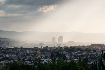 The evening sun shines on the city through the thick clouds (Brno, Czech republic)