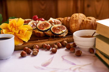 Obraz na płótnie Canvas Coffee and croissant for Breakfast. French toast with figs near a yellow rose. High quality photo