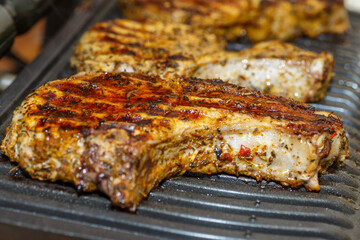 grilling steaks on a flaming grill