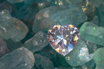 .close up heart shaped diamond put on raw sky blue gemstones