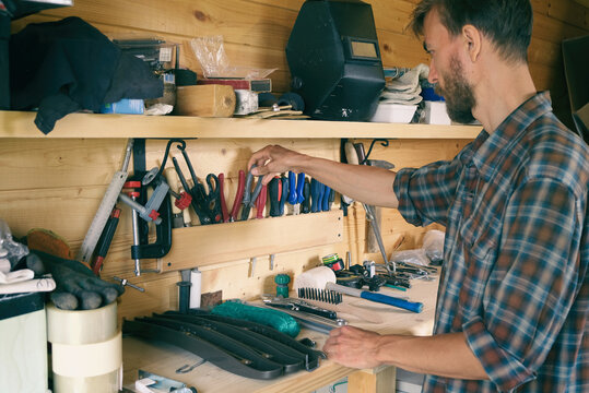 Joiner woodworker choosing construction carpentry tools in his workshop. DIY concept.
