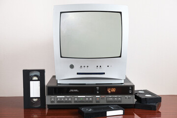Old silver TV with built-in DVD player and vintage VCR from 1980s, 1990s, 2000s.