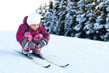 4 year old girl on cross-country skiing, no sticks. Rides from the mountain. Family sports. Beautiful winter landscape.