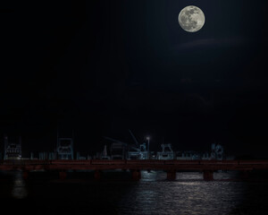 Ethereal view of a full moon over docked sport fishing boats in Florida