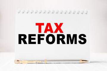Fototapeta premium Notepad with inscriptions TAX REFORMS on a white background. business concept.
