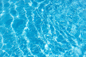 View of surface of turquoise water in swimming pool, summer background. Gradient of color with waves. Concept rest, travel, wellness, spa procedures, season of vacations, sport