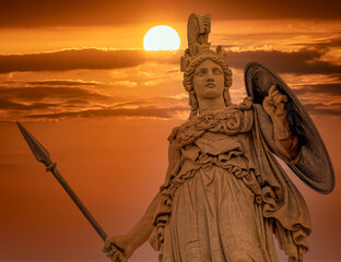 Athena statue the ancient Greek goddess of wisdom and knowledge illuminated by dramatic sun burned sky, Athens Greece