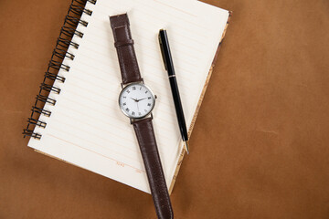watch and pen on notepad