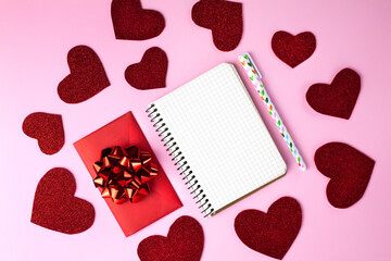 Blank notepad with copy space to write your own text, pen and red envelope on the pink background....