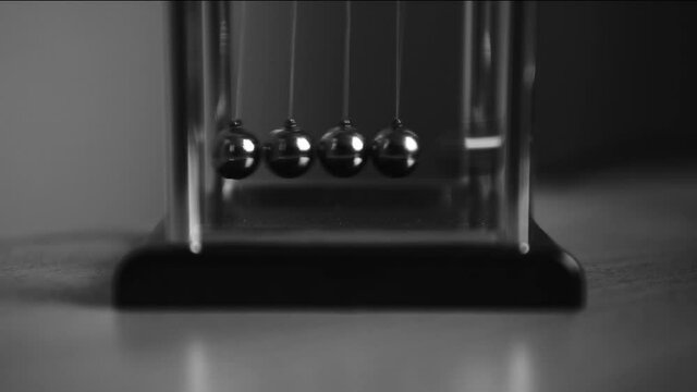 Newton's Cradle swinging metal balls. Law of Physics, pendulum