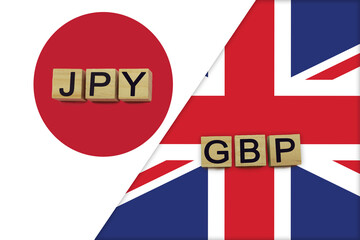 Japan and United Kingdom currencies codes on national flags background