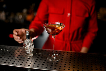 wineglass with alcoholic drink decorated with hop stands on bar counter