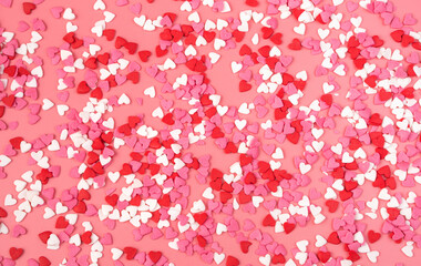 Romantic background with small hearts on pink background. The view from the top. Concept February 14.