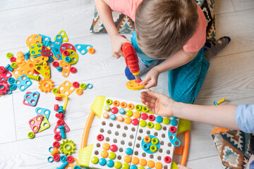 Baby boy playing in creative game. Preschool child development background. Montessori system.