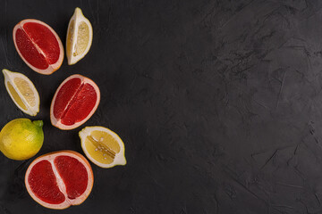Slices of lemon and grapefruit on the black table.Fruits  background.