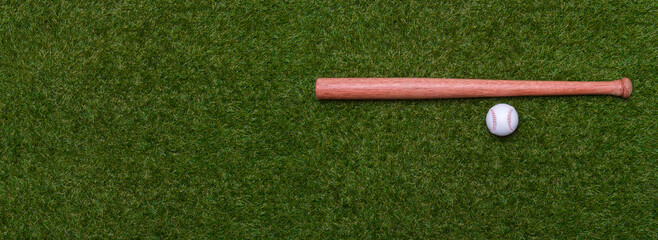 Baseball bat and ball on green grass field.  Sport theme background with copy space for text and...