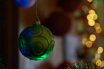 A green ball with ornaments on the Christmas tree 