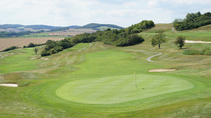 Aerial view of luxury modern golf course with large green and sandy bunker hazards