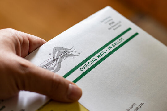Hand holding official mail-in ballot for 2020 US general election