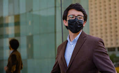 Young latin man wearing a face mask for protective reasons during the covid 19 pandemic