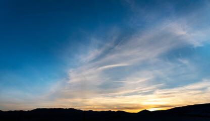 Beautiful panoramic sunset over the mountains silhouette.