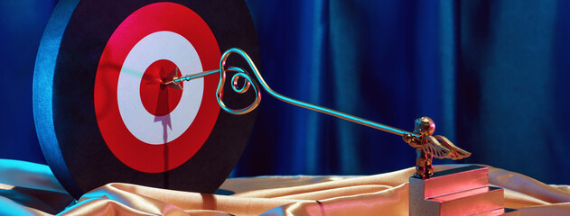 Small golden cupid marks his target with an arrow at the heart, valentine's day concept.