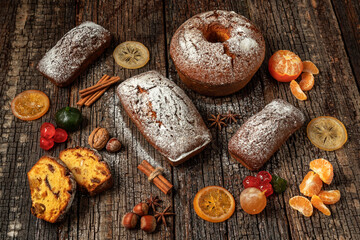 Christmas composition of dried fruits and stollen, with tangerine, on a wooden textured table, with spices. At Christmas.